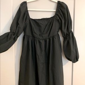 Simple long sleeve black dress with cinched bands at the elbows.